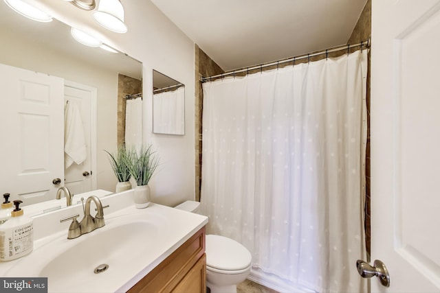 bathroom featuring toilet, a shower with shower curtain, and vanity