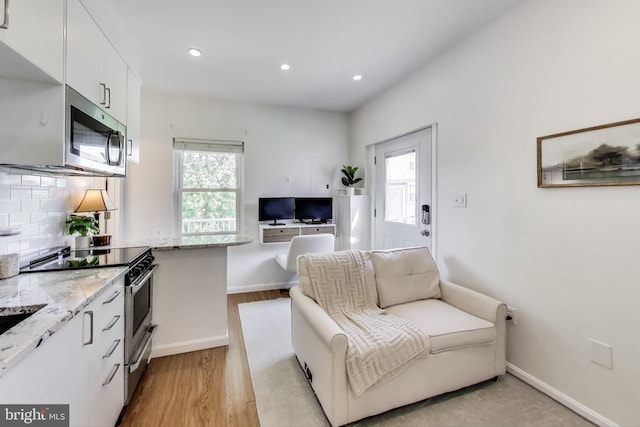 living room featuring recessed lighting, light wood-style flooring, baseboards, and a wealth of natural light