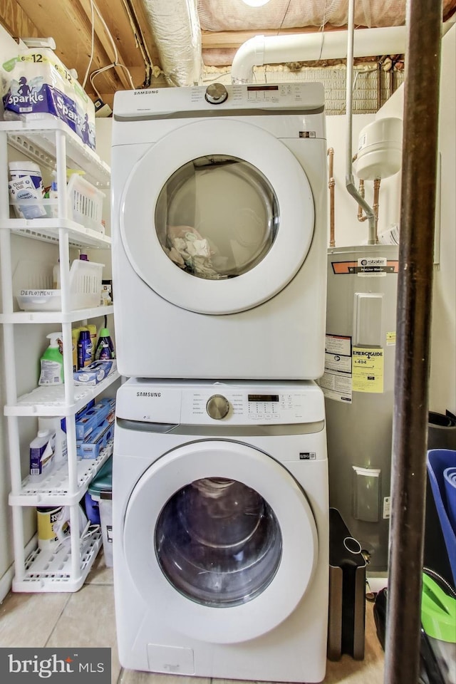 washroom with electric water heater, tile patterned floors, stacked washer / drying machine, and laundry area