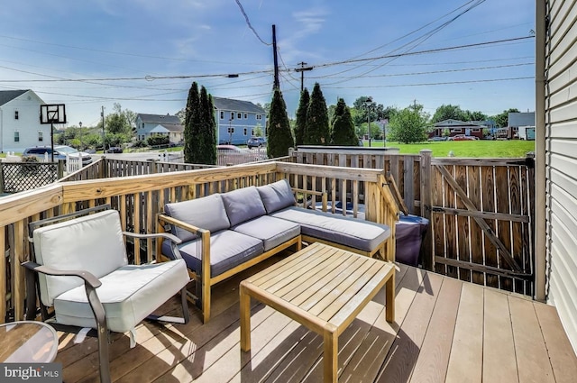 wooden terrace with a residential view, an outdoor living space, and a fenced backyard