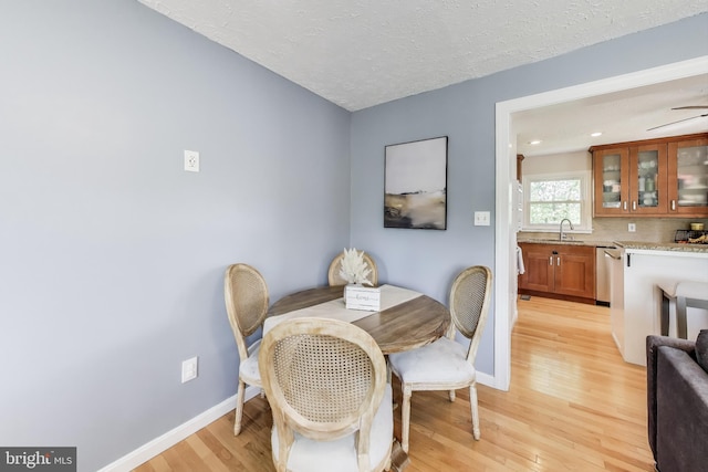 dining room featuring ceiling fan, light wood-style floors, a textured ceiling, recessed lighting, and baseboards