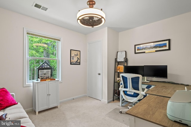 home office featuring baseboards, visible vents, and light carpet
