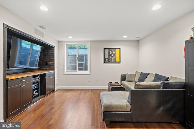 living room with baseboards, recessed lighting, light wood-style flooring, and visible vents