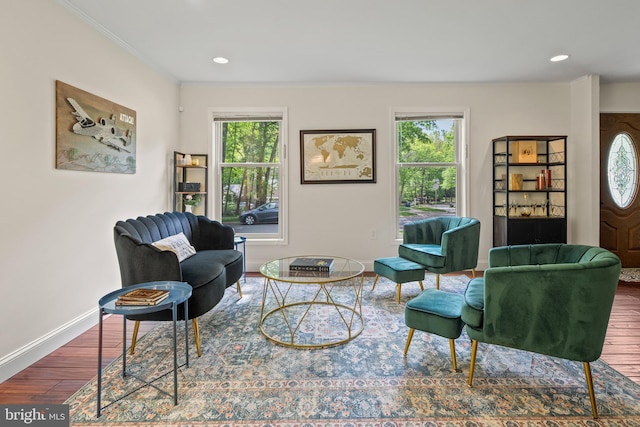 living area featuring crown molding, recessed lighting, baseboards, and wood finished floors