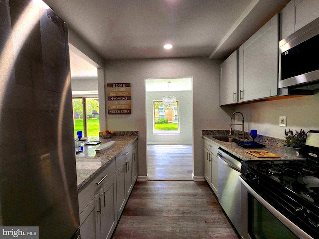 3811 Saint Barnabas Rd Unit T2, Suitland, MD 20746 - kitchen featuring appliances with stainless steel finishes, a sink, a chandelier, wood finished floors, and light stone countertops