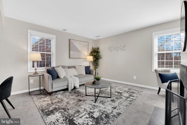carpeted living area featuring baseboards
