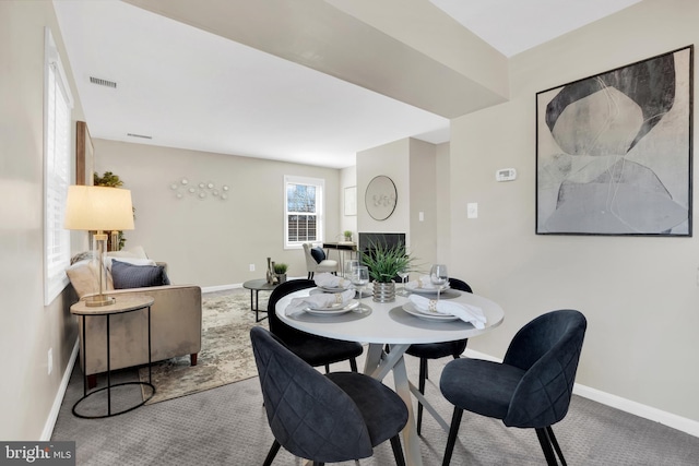 carpeted dining area with baseboards and visible vents