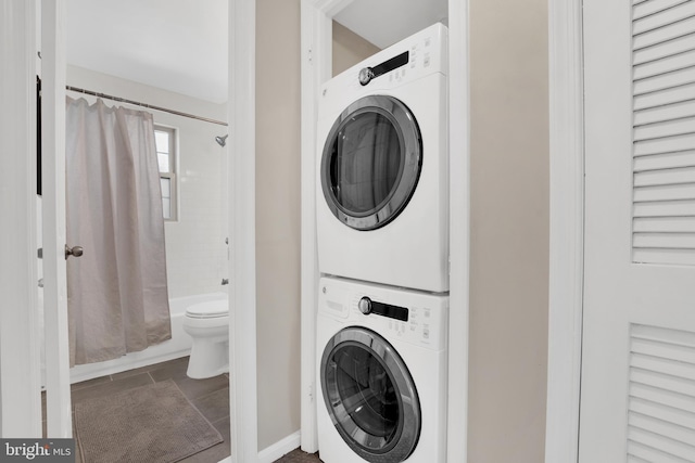 laundry area with laundry area, stacked washing maching and dryer, and tile patterned flooring