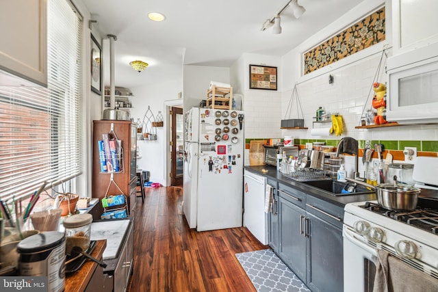 5217 Greene St, Philadelphia, PA 19144 - kitchen with dark countertops, a sink, white appliances, decorative backsplash, and dark wood-type flooring