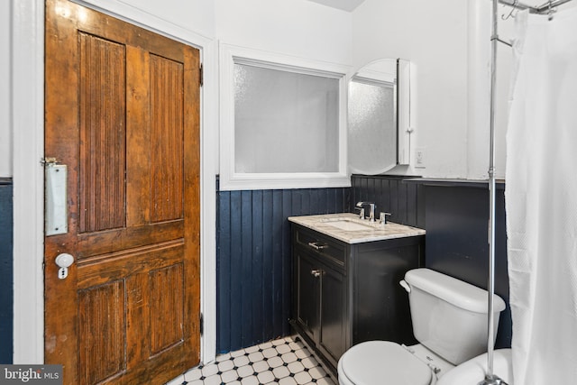 5217 Greene St, Philadelphia, PA 19144 - bathroom featuring vanity, toilet, tile patterned floors, wood walls, and a wainscoted wall
