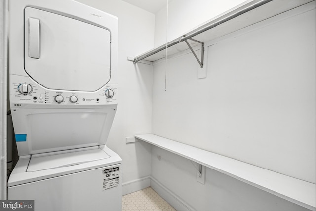 5217 Greene St, Philadelphia, PA 19144 - laundry room with light tile patterned floors, laundry area, stacked washing maching and dryer, and baseboards