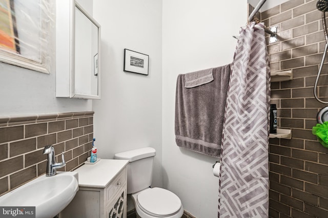 5217 Greene St, Philadelphia, PA 19144 - bathroom featuring toilet, tiled shower, a sink, and tile walls