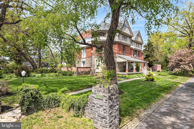 5217 Greene St, Philadelphia, PA 19144 - view of front facade featuring covered porch, brick siding, and a front yard