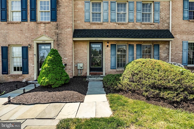 view of exterior entry with brick siding