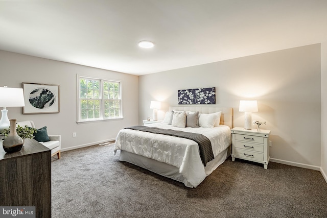 bedroom featuring baseboards and dark carpet