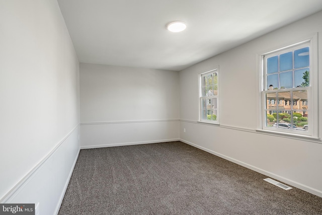 carpeted spare room with baseboards and visible vents