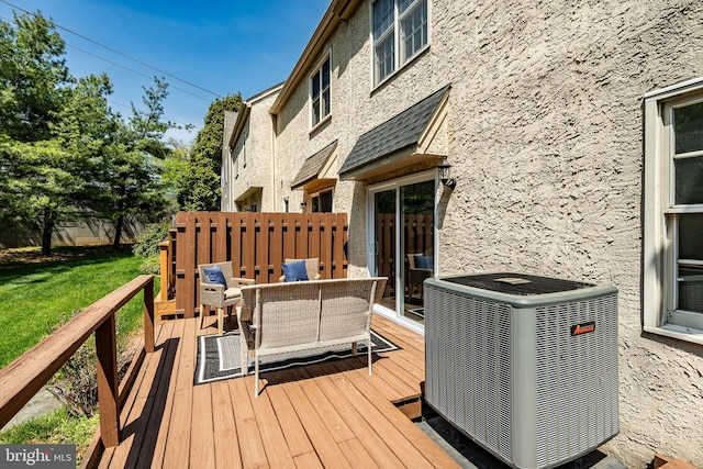 deck featuring an outdoor hangout area, a lawn, and cooling unit