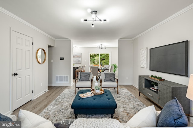 living area with crown molding, visible vents, and wood finished floors