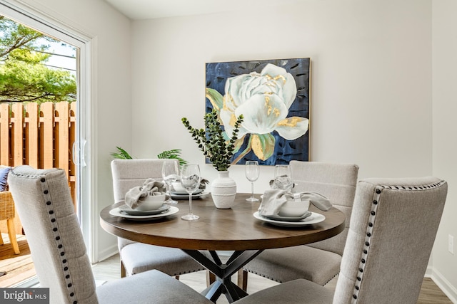 dining space with baseboards and wood finished floors