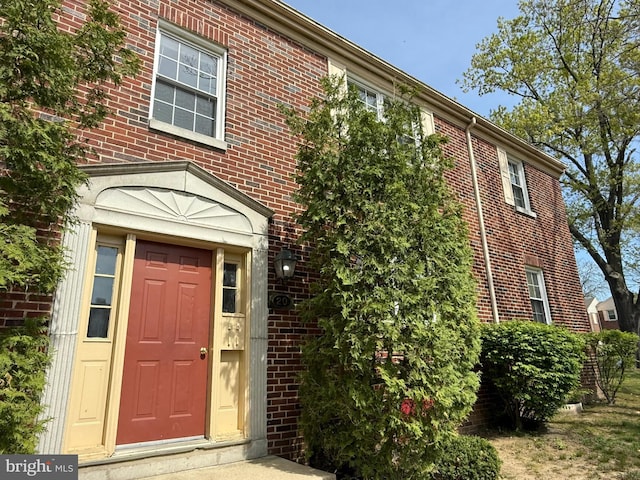 entrance to property featuring brick siding