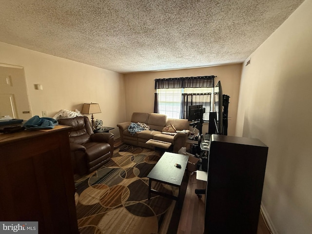 living area featuring baseboards and a textured ceiling