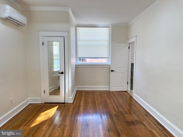 entryway with an AC wall unit, ornamental molding, baseboards, and wood finished floors