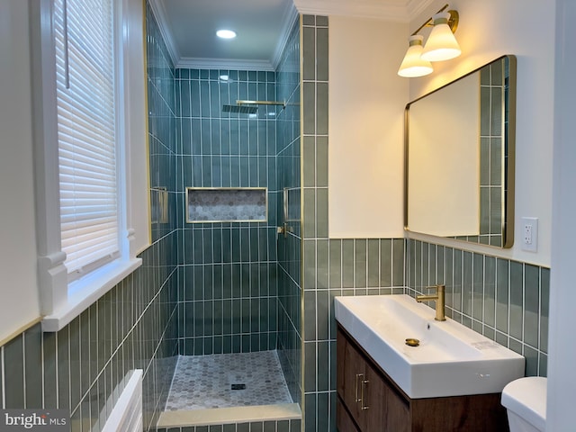 bathroom featuring ornamental molding, a tile shower, toilet, and tile walls