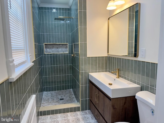 full bath featuring tile walls, walk in shower, vanity, toilet, and ornamental molding