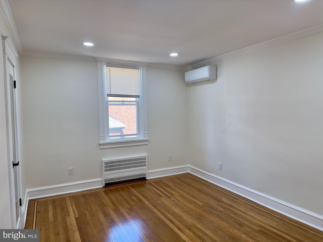 empty room with an AC wall unit, baseboards, wood finished floors, and radiator