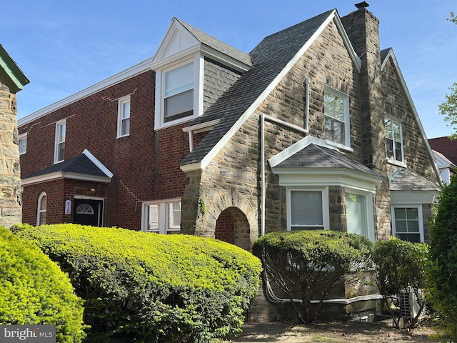 view of front of property featuring a chimney and stone siding
