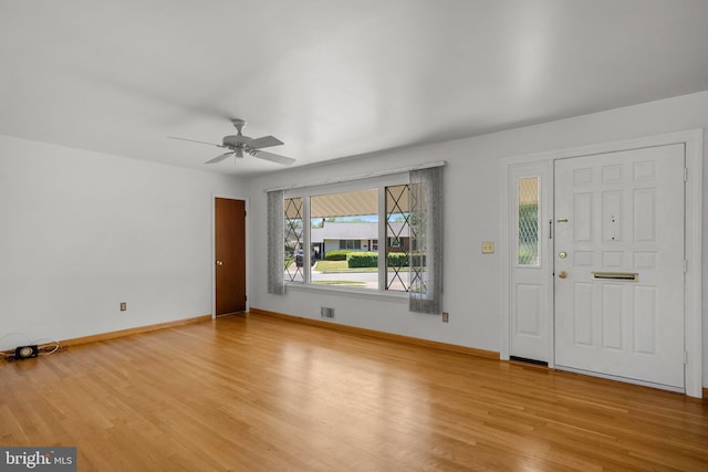 foyer with baseboards, ceiling fan, light wood-type flooring, and visible vents