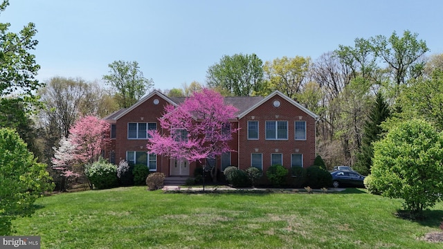 view of front facade featuring brick siding and a front yard