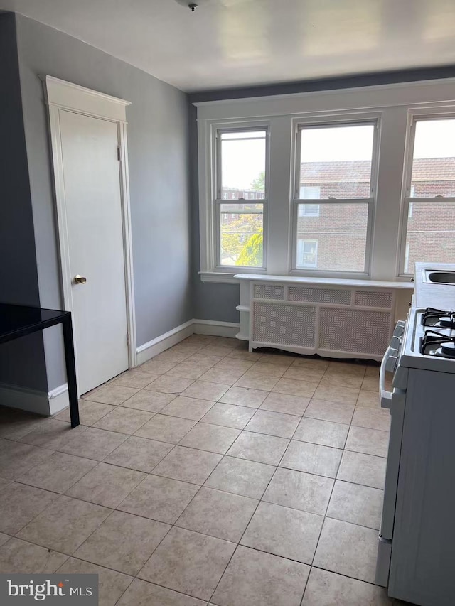 dining space featuring radiator, baseboards, and light tile patterned flooring