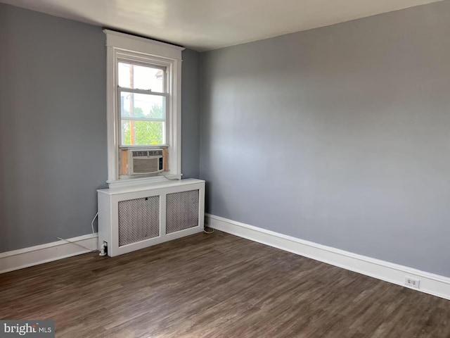 unfurnished room with radiator, baseboards, cooling unit, and dark wood-style floors
