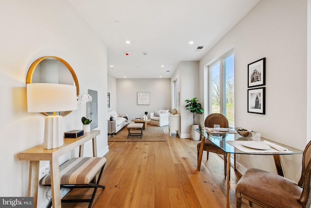 corridor with light wood-type flooring, recessed lighting, baseboards, and visible vents
