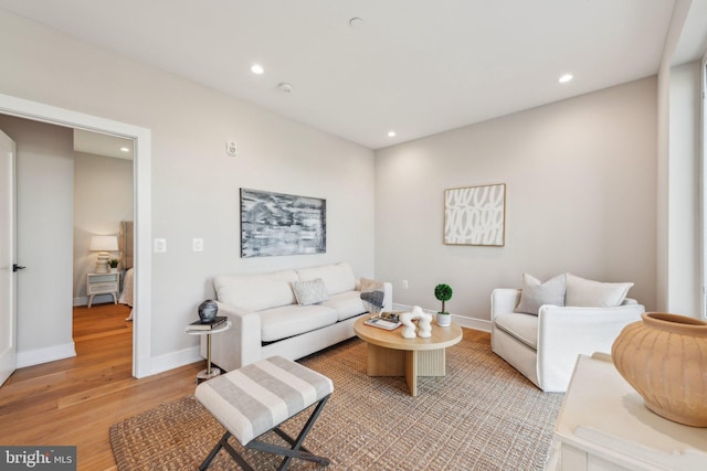 living room featuring light wood-type flooring, recessed lighting, and baseboards