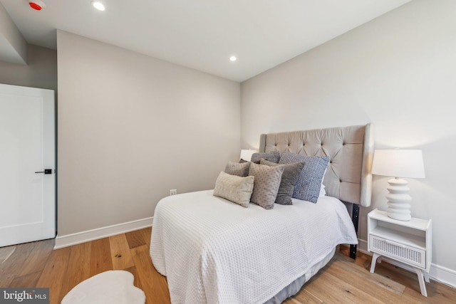 bedroom with baseboards, recessed lighting, wood finished floors, and visible vents