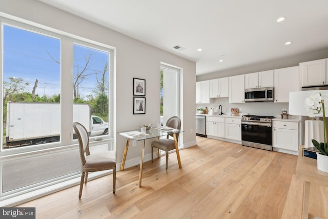 kitchen with visible vents, recessed lighting, white cabinetry, a sink, and appliances with stainless steel finishes