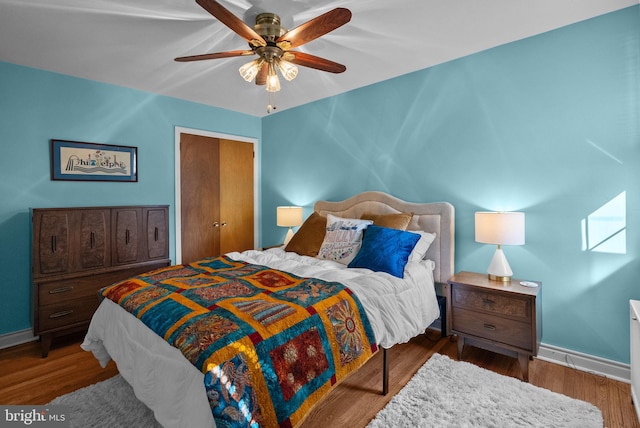 bedroom with baseboards, ceiling fan, and wood finished floors
