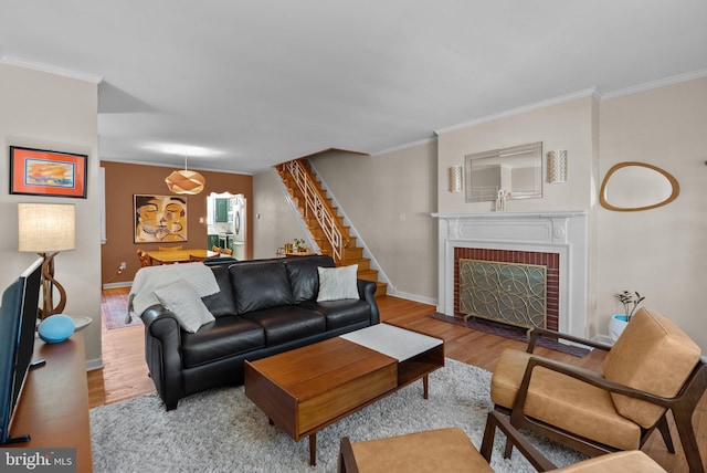 living area featuring ornamental molding, stairs, and wood finished floors