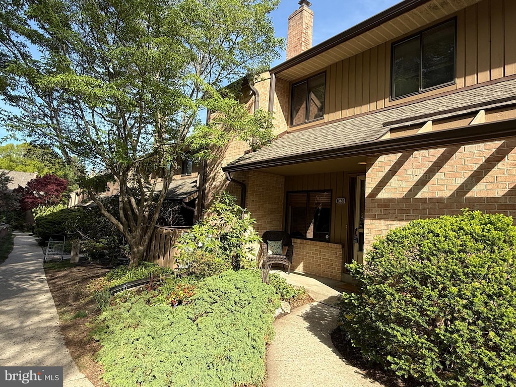 view of property exterior featuring a shingled roof and a chimney