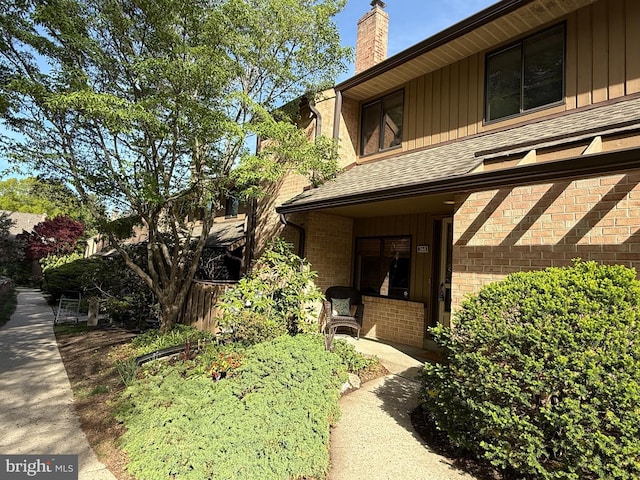 view of property exterior featuring a shingled roof and a chimney