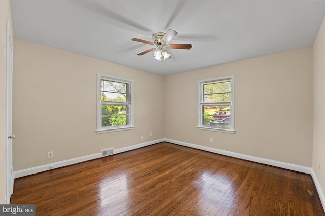 spare room featuring baseboards, plenty of natural light, hardwood / wood-style flooring, and visible vents