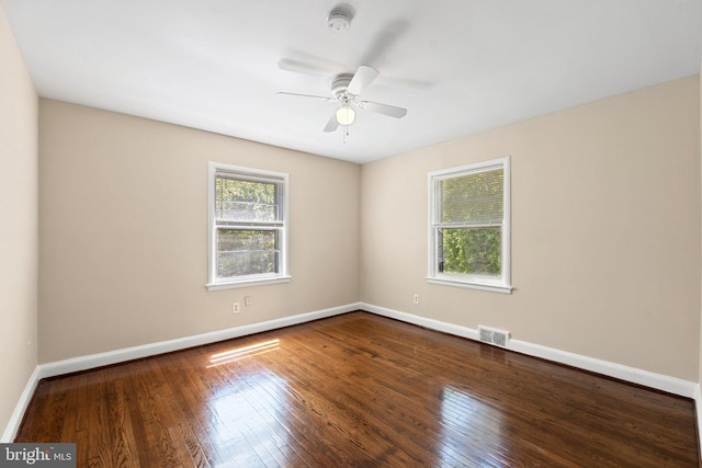 empty room with baseboards, a ceiling fan, hardwood / wood-style flooring, and visible vents