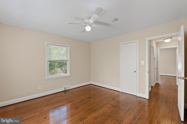 unfurnished room with baseboards, ceiling fan, hardwood / wood-style floors, and visible vents