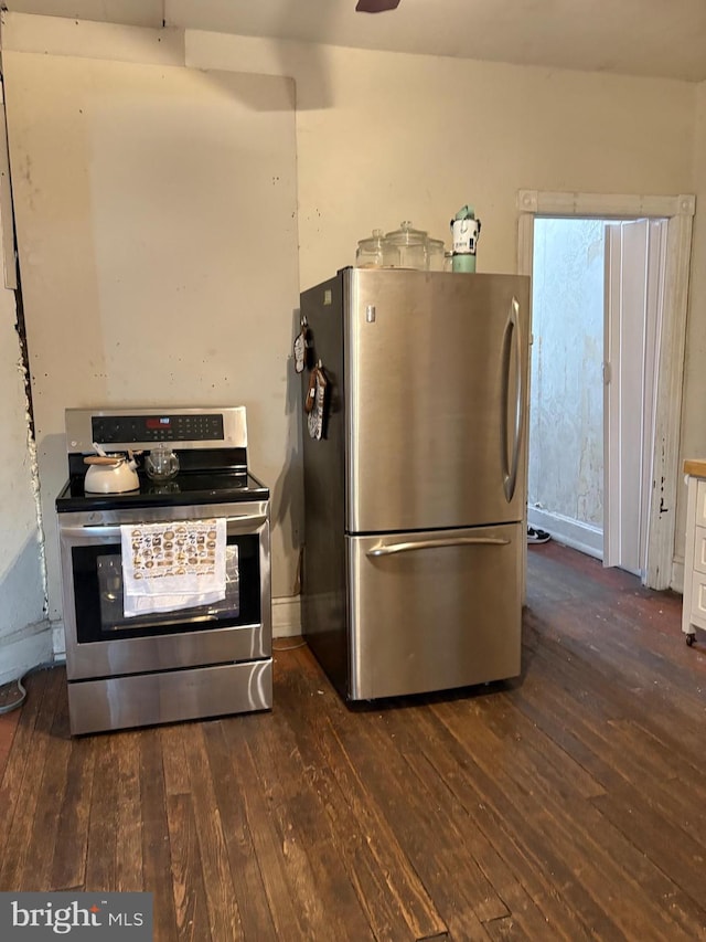 kitchen featuring baseboards, appliances with stainless steel finishes, and dark wood-style floors
