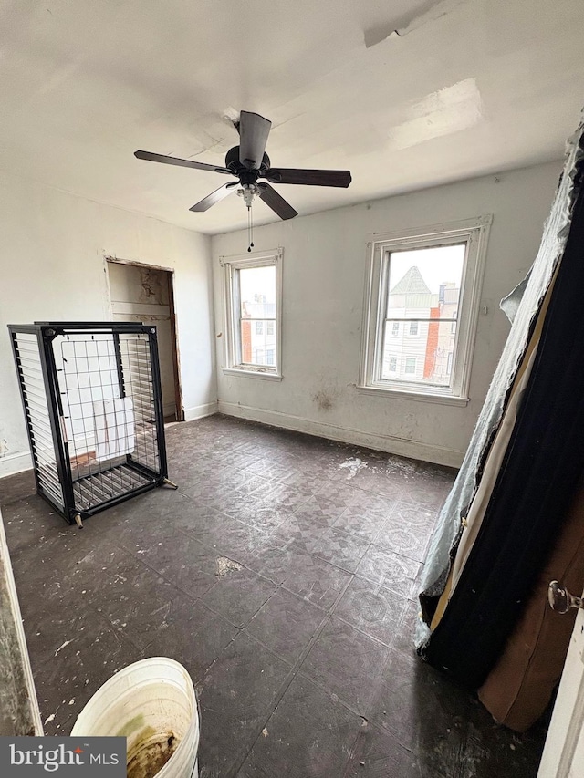 interior space with ceiling fan and baseboards