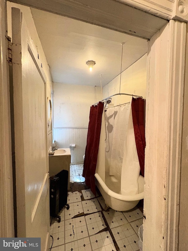 full bath with tile patterned floors, wood walls, and a wainscoted wall