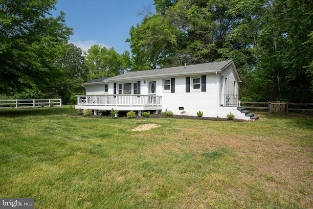 ranch-style home featuring fence, a wooden deck, and a front yard