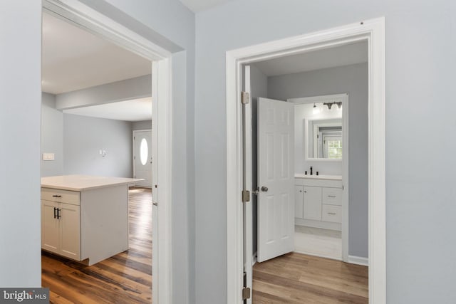 hallway with baseboards, wood finished floors, and a wealth of natural light